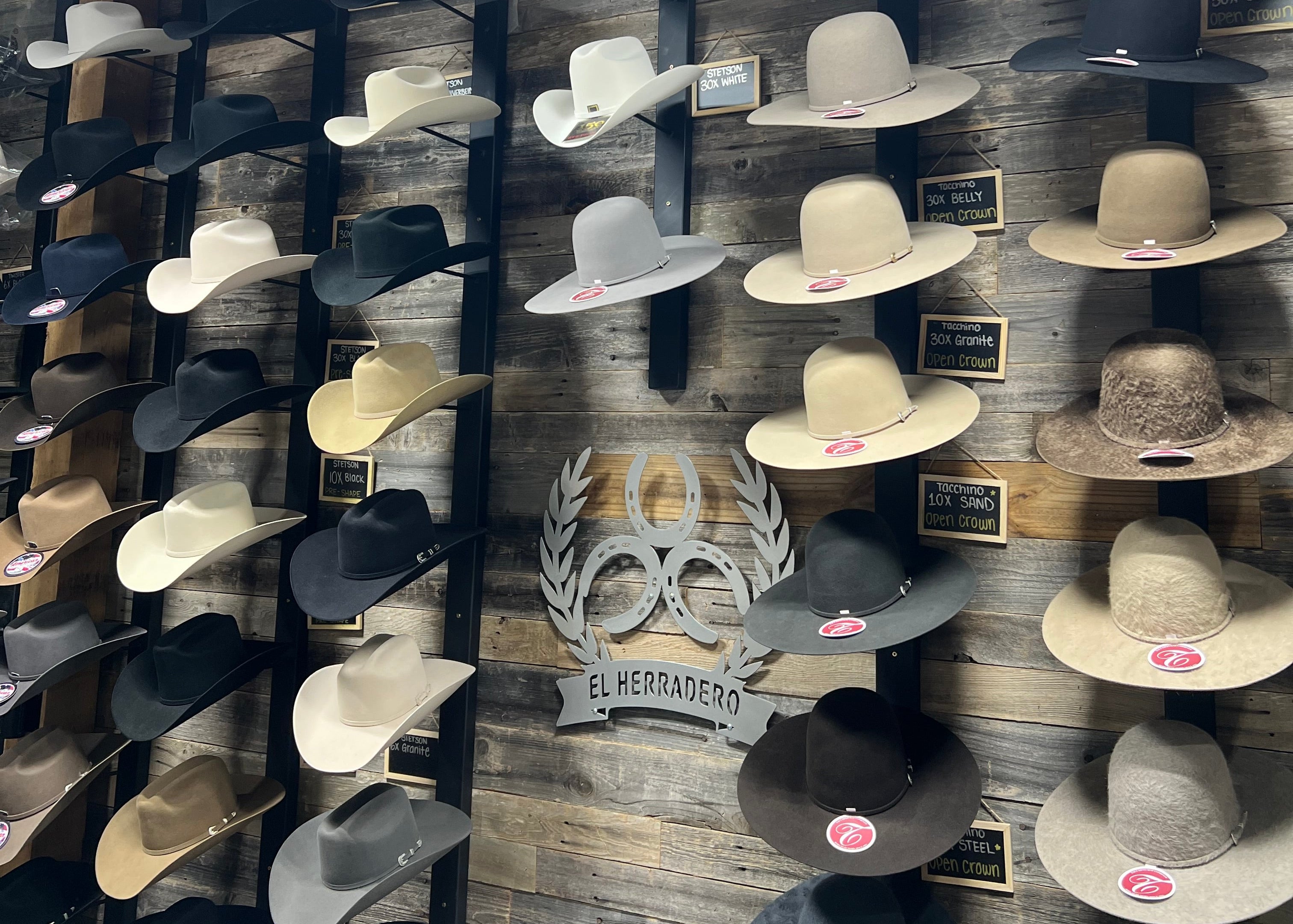 Wall display of various hats on a wooden wall.